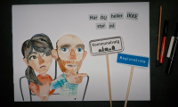 Screenshot fra videoen: to personer, byskilte og tekst